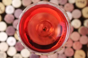 Rosé Wein von oben. Glas steht auf vielen Korken.