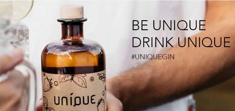 Unique Gin Banner. Eine Hand hält die Flasche. Auf dem Bild steht "be unique drink uniqe".