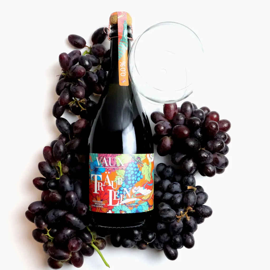 Flasche Vaux Träublein mit roten Weintrauben und Glass