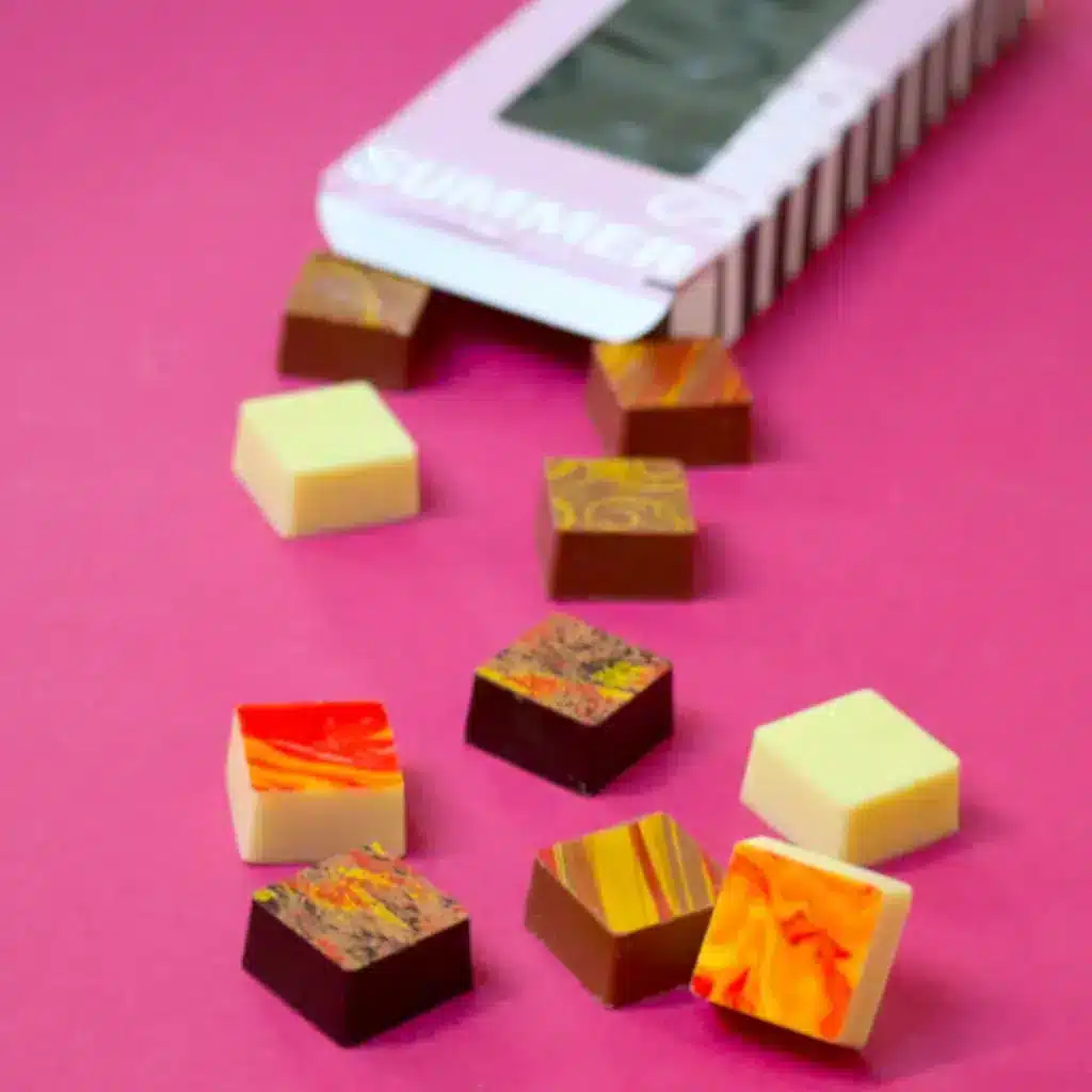 Art of Chocolate-Pralinen-auf pinkem Tisch